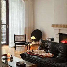 Living room with a leather sofa beside a fireplace