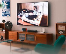 TV console with a turntable on screen and a green chair