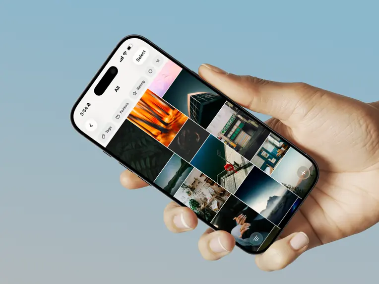 A hand holding an iPhone with a Hive image grid